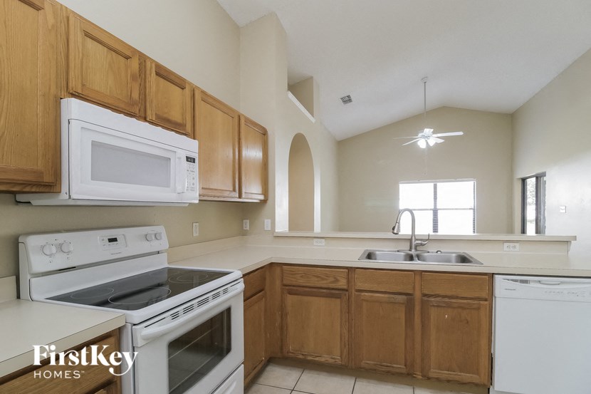 a kitchen with white appliances and wooden cabinets