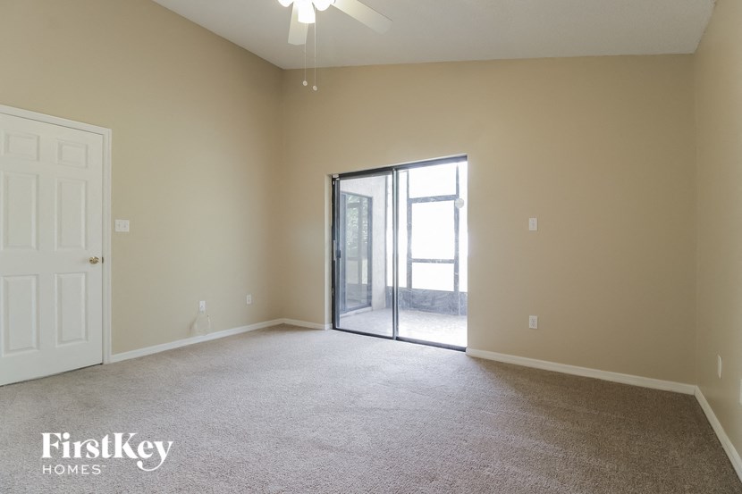 an empty living room with a sliding glass door to a patio