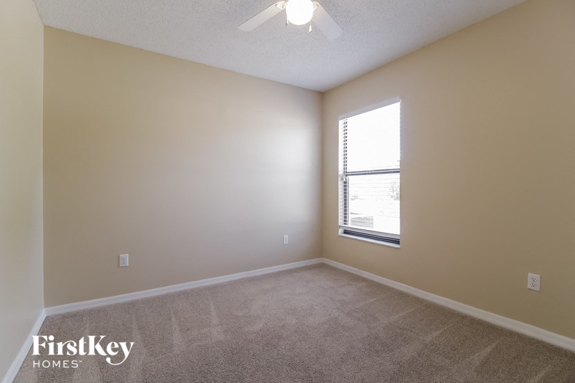 an empty living room with a window and carpeting