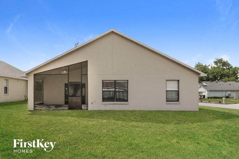 the outside of a white house with a grass yard
