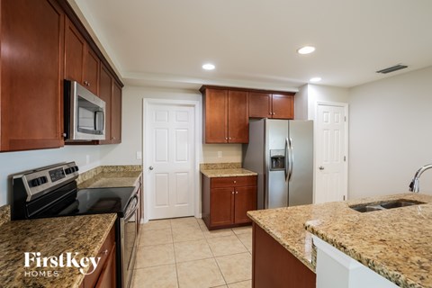 A kitchen with brown cabinets and a granite countertop.