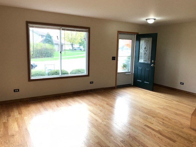 an empty living room with a large window and a blue door