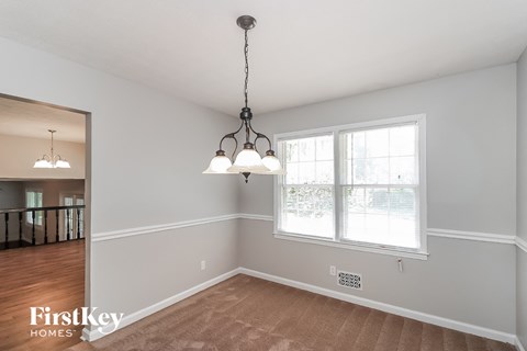 an empty dining room with two lamps and a window