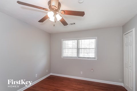 a bedroom with a ceiling fan and a window