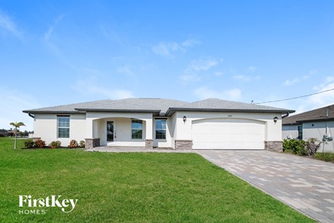 A house with a white garage door is for sale by FirstKey Homes.