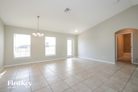 A spacious room with a chandelier and a door on the right side.