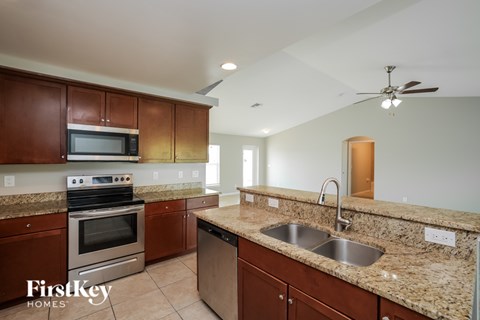 A kitchen with brown cabinets and granite countertops.