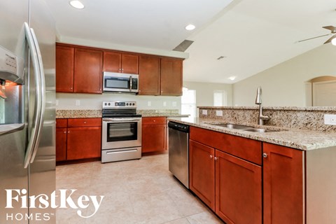 A kitchen with brown cabinets and a stainless steel refrigerator.