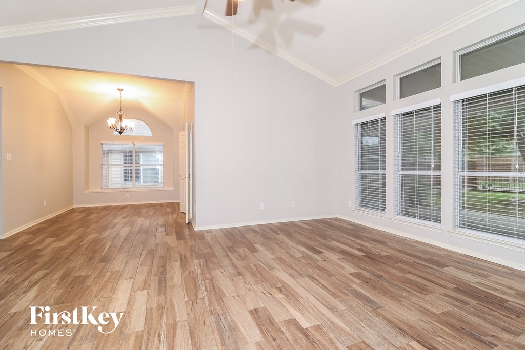 a living room with wood floors and large windows