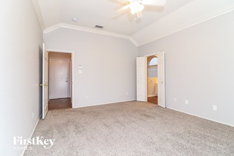 a bedroom with white walls and carpet and a door to a hallway