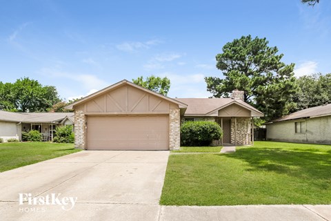 a home with a garage door and a lawn