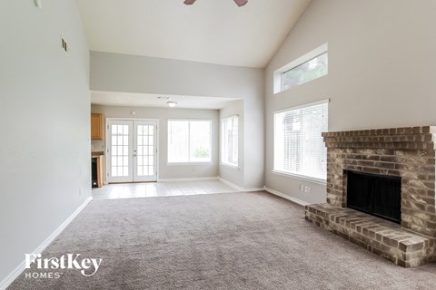 a living room with a fireplace and a carpeted floor