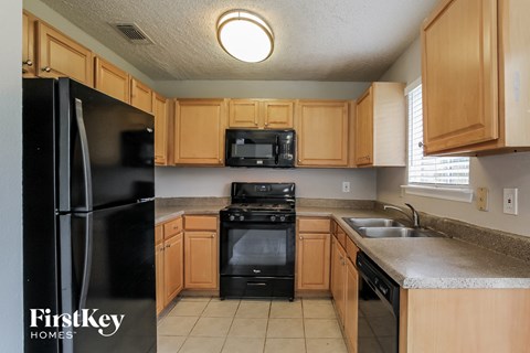 a kitchen with wooden cabinets and black appliances