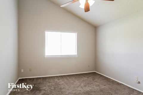 a bedroom with a ceiling fan and a window