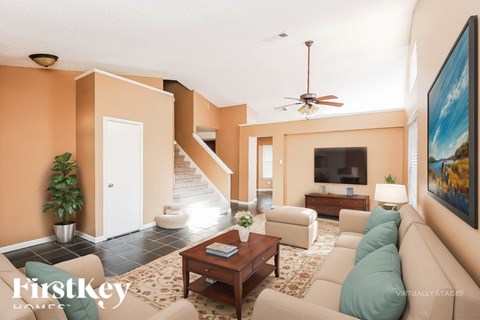 A living room with a brown coffee table and a large painting on the wall.