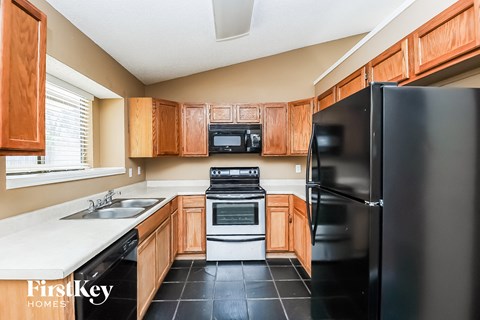 A kitchen with wooden cabinets and black appliances.