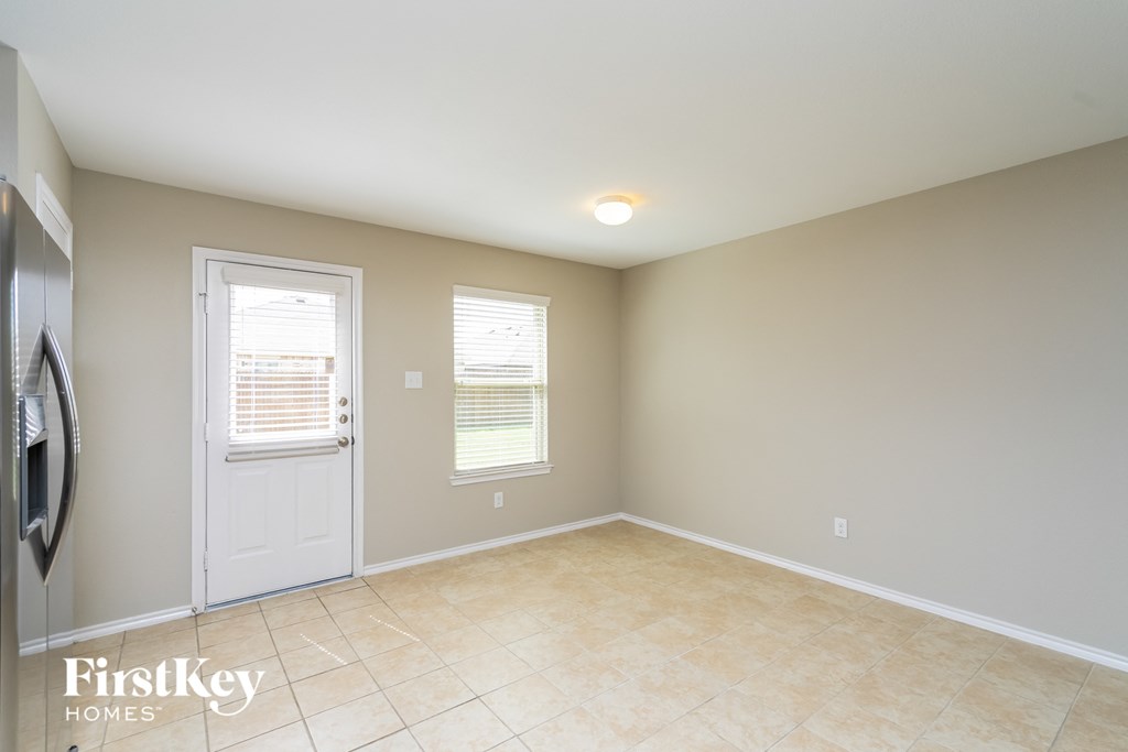 an empty living room with a white door and a tiled floor