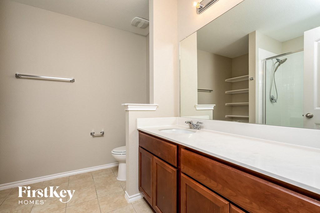 a bathroom with a large mirror and a sink and a toilet