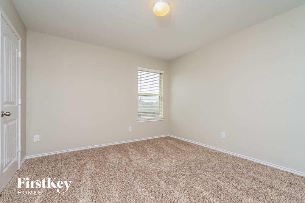the spacious living room with carpeting and a window