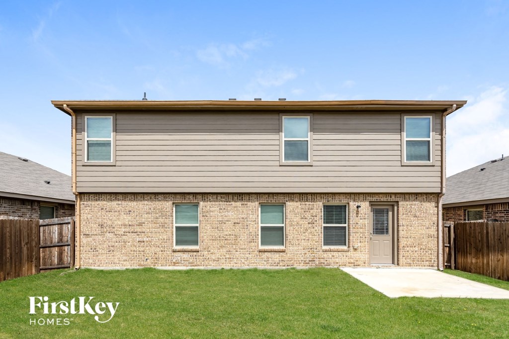 side view of a brick house with tan siding