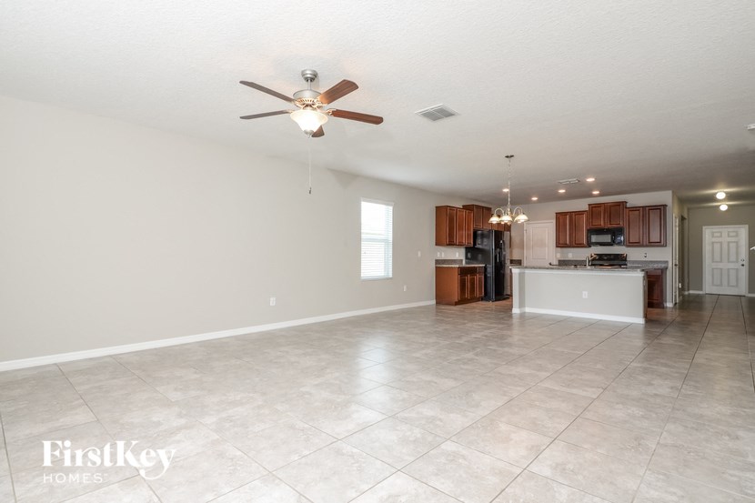 an empty kitchen and living room with a ceiling fan
