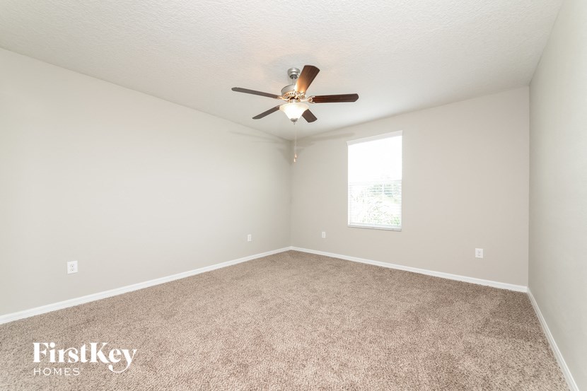a bedroom with carpet and a ceiling fan