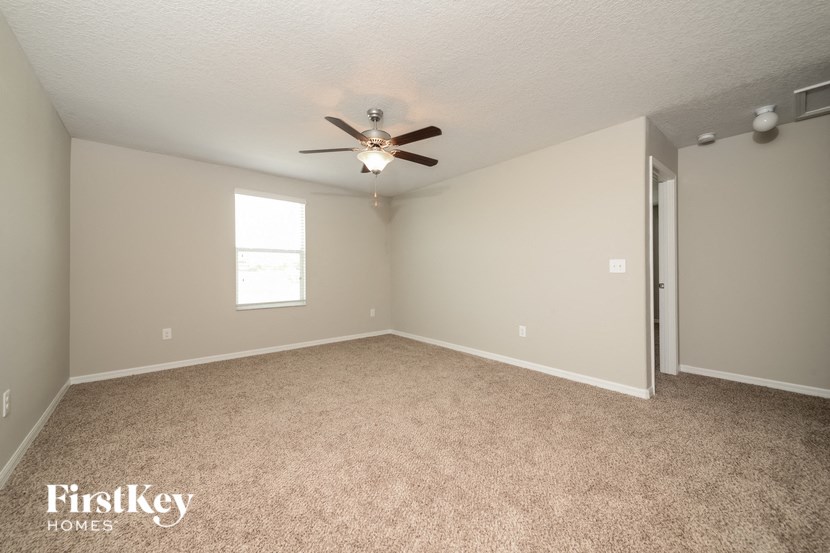 a bedroom with carpet and a ceiling fan