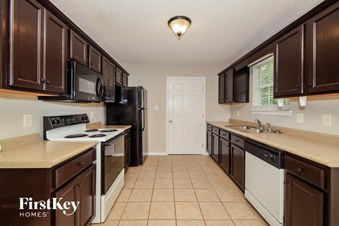 A kitchen with brown cabinets and a white door.
