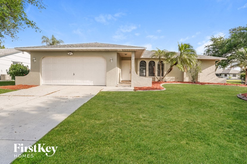 A house with a garage and a driveway in front of it.