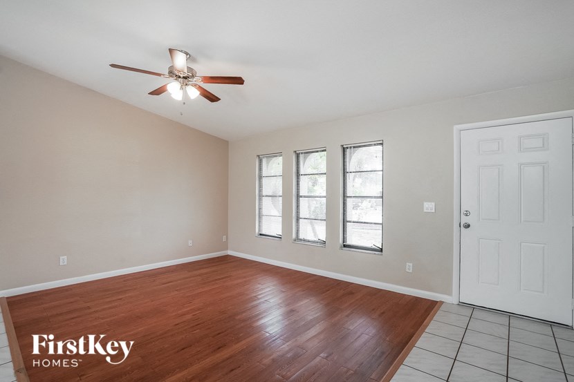 A room with a wooden floor and a ceiling fan.