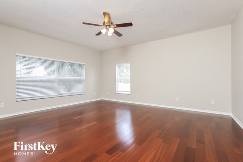 a living room with wood floors and a ceiling fan