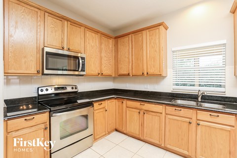 a kitchen with wooden cabinets and a stove and microwave