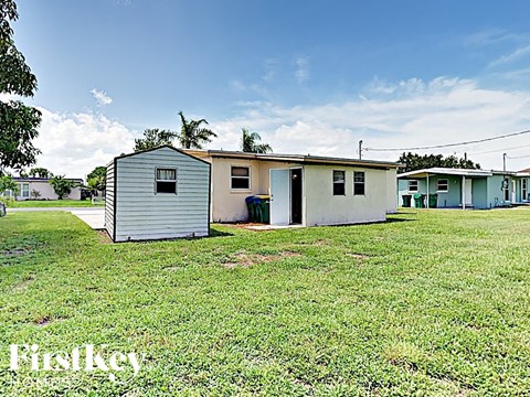 A row of mobile homes in a grassy area with a blue sky above.
