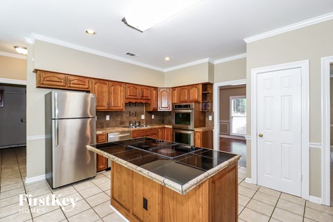 A kitchen with wooden cabinets and a stainless steel refrigerator.