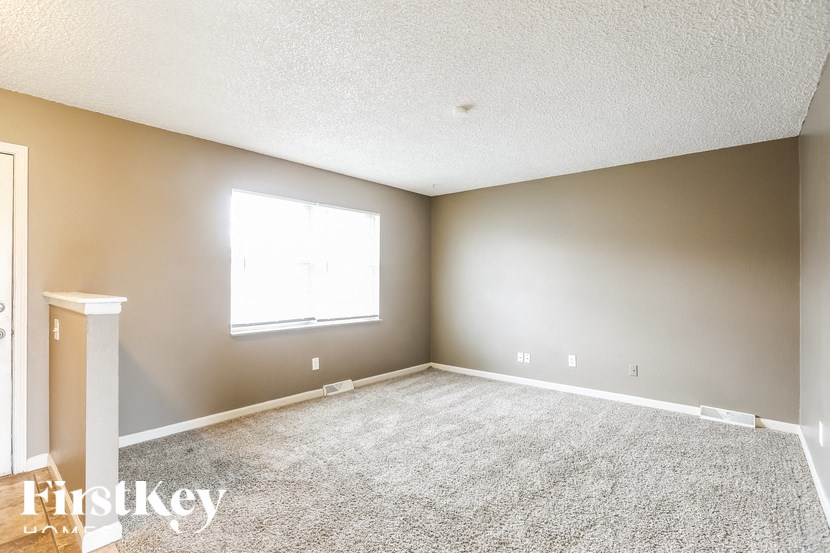 A room with a carpeted floor and a window.
