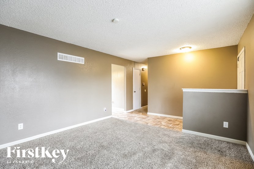 A room with a carpeted floor and a wall-mounted light fixture.