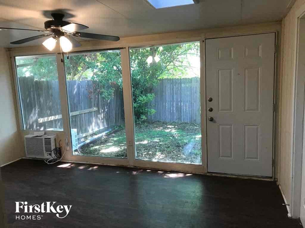 a living room with a large window and a ceiling fan