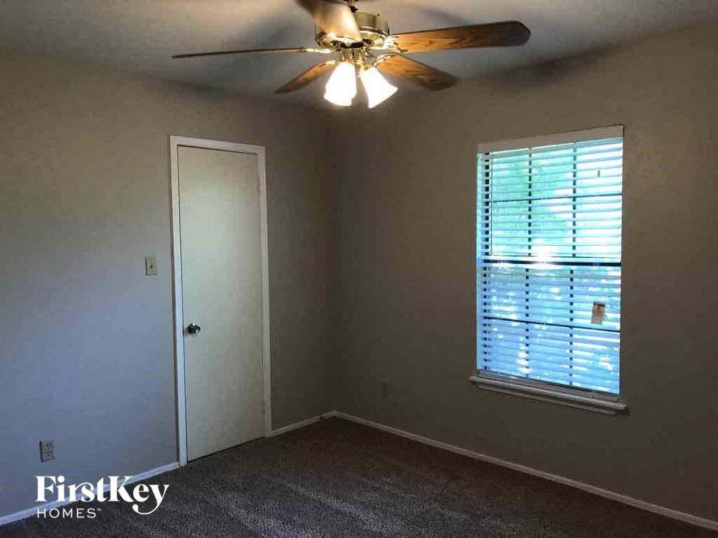 a bedroom with a ceiling fan and a window