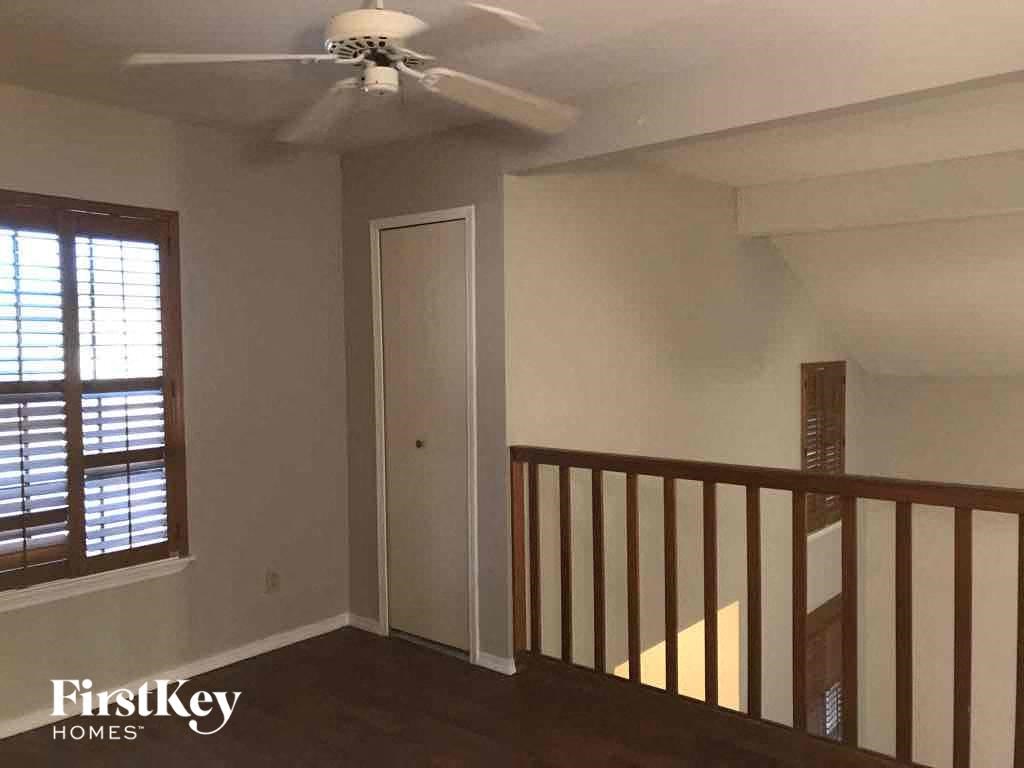 a living room with a staircase and a ceiling fan