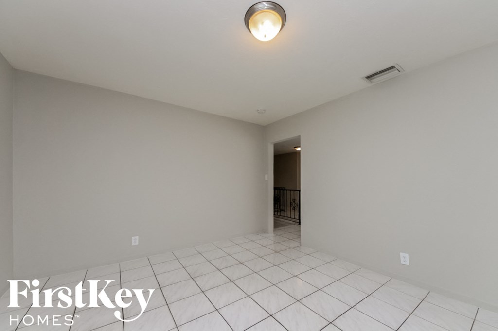 a empty room with a white tile floor and a light on the ceiling
