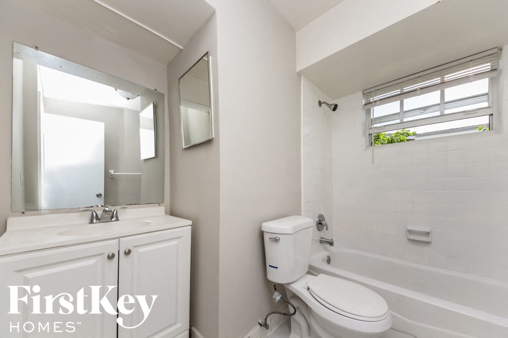 a bathroom with a toilet and a sink and a mirror