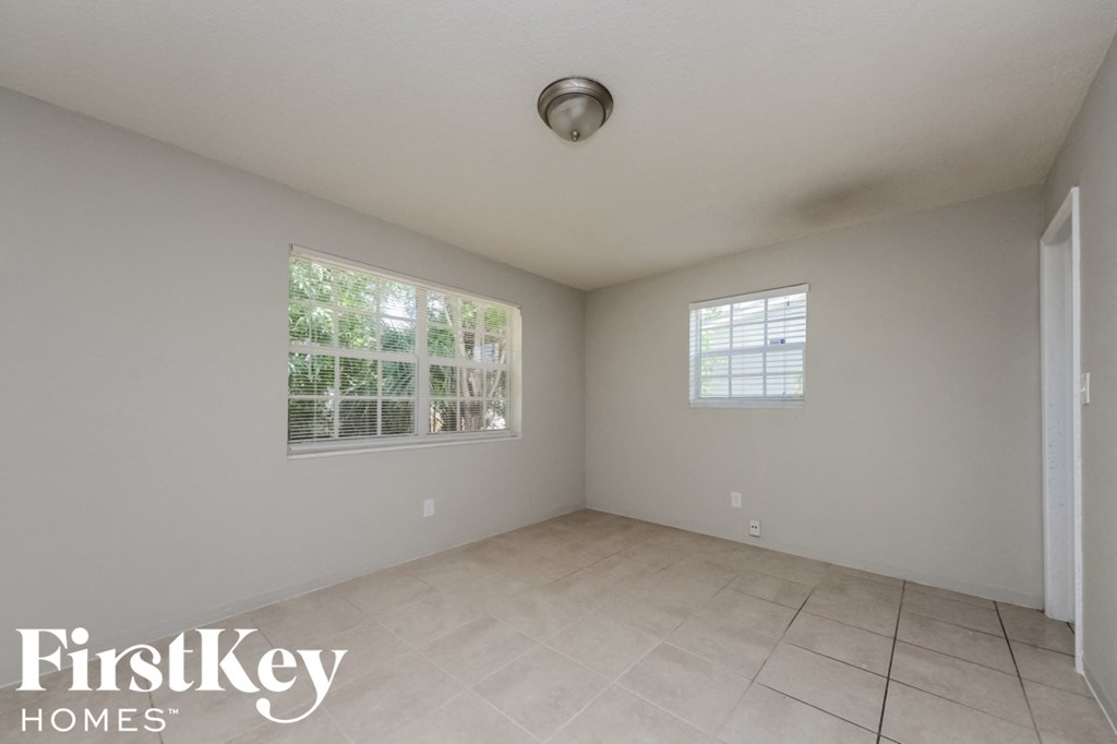 the spacious living room has tile flooring and two windows