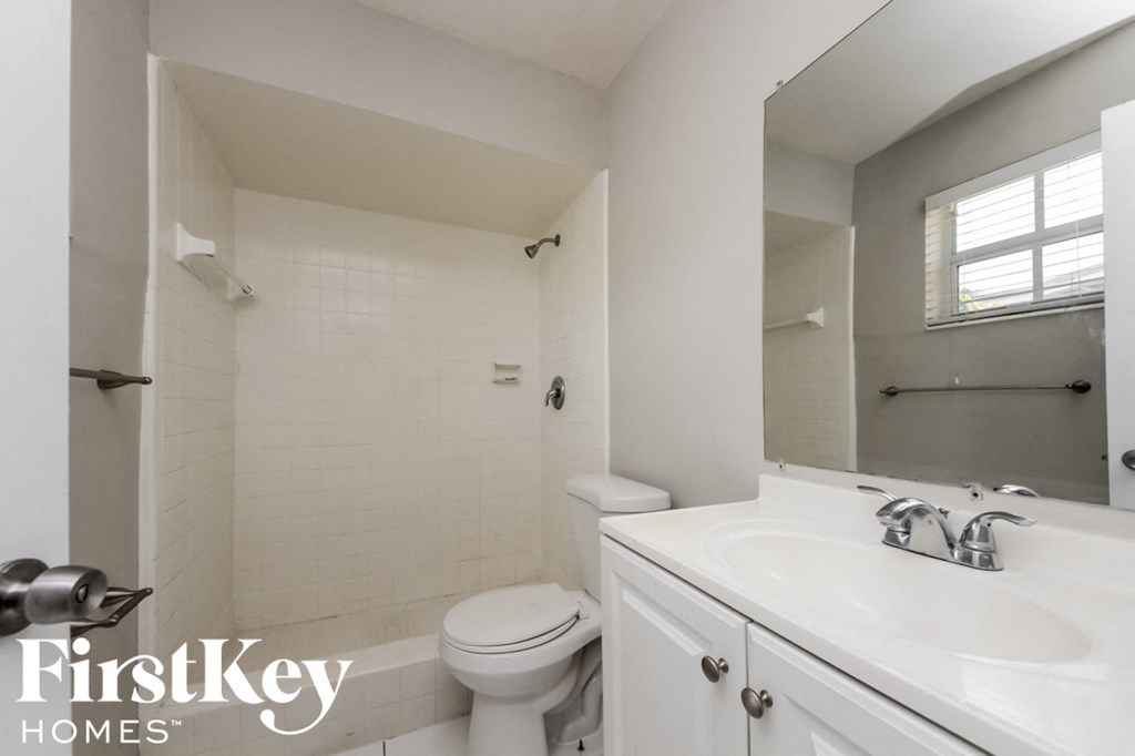 a white bathroom with a sink toilet and mirror