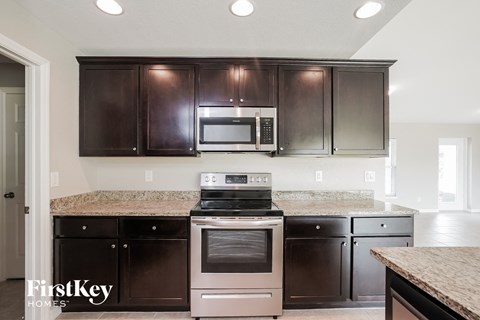 A kitchen with dark brown cabinets and stainless steel appliances.