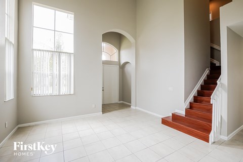 A spacious room with a staircase leading to the upper floor.