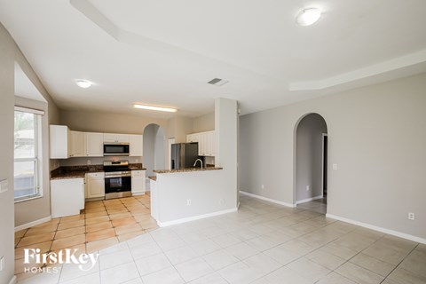A spacious kitchen with a tiled floor and a large island in the middle.