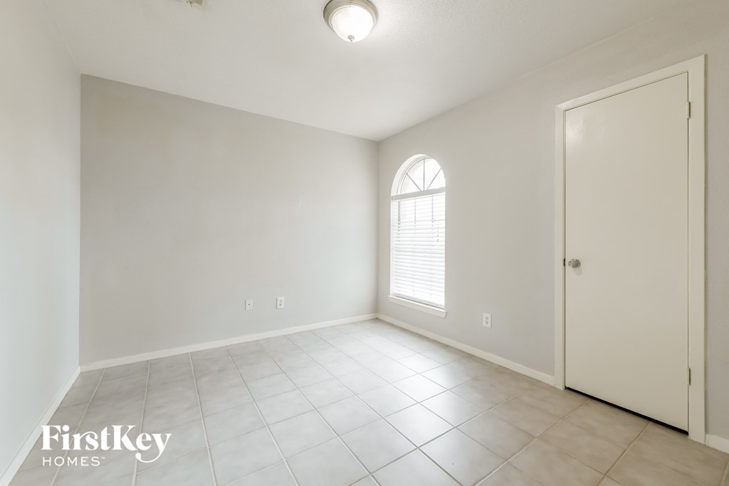 A room with a window and a door is available for rent.