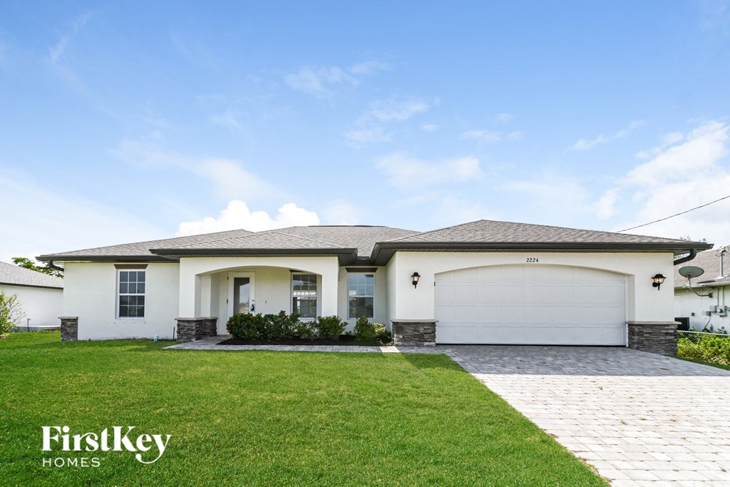 a white house with a lawn and a garage door
