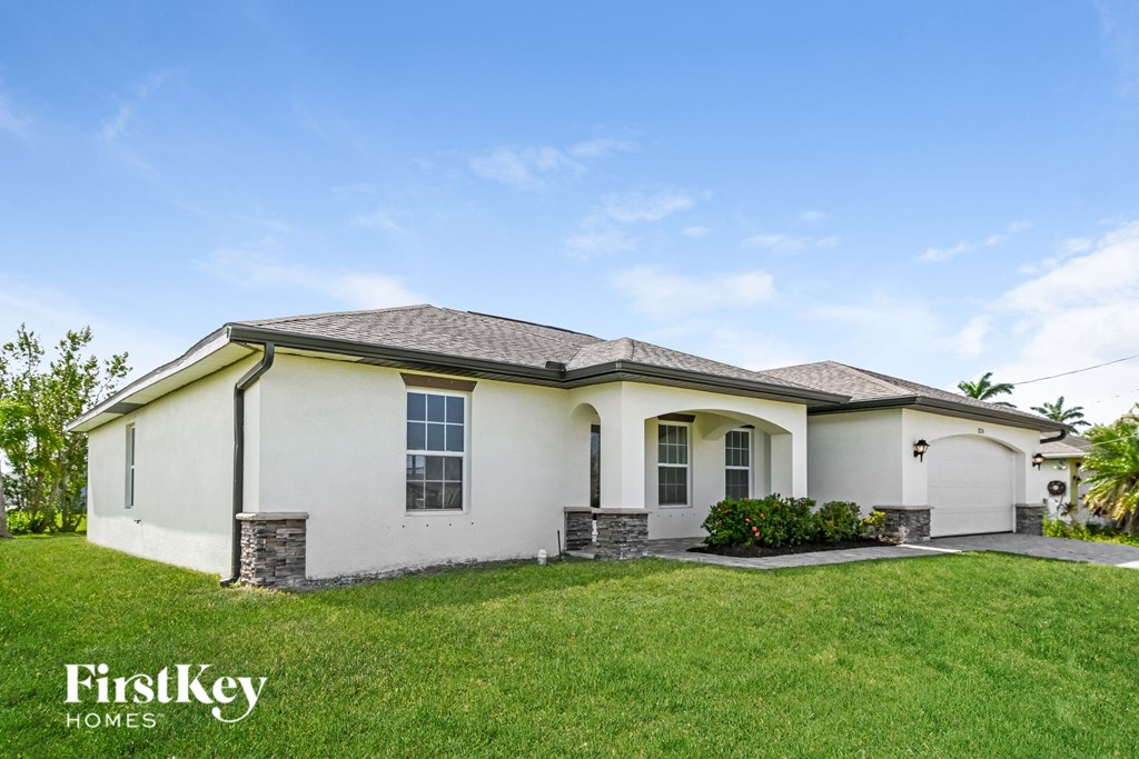 a white house with a lawn and a blue sky