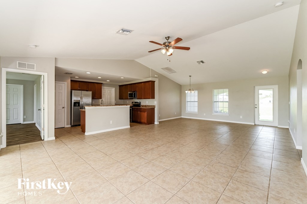 an empty kitchen and living room with a ceiling fan